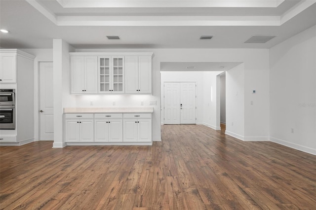 kitchen with glass insert cabinets, white cabinetry, visible vents, and dark wood finished floors