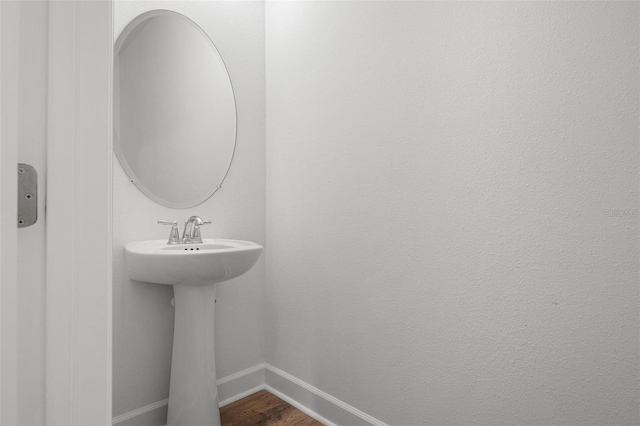 bathroom with wood finished floors and baseboards