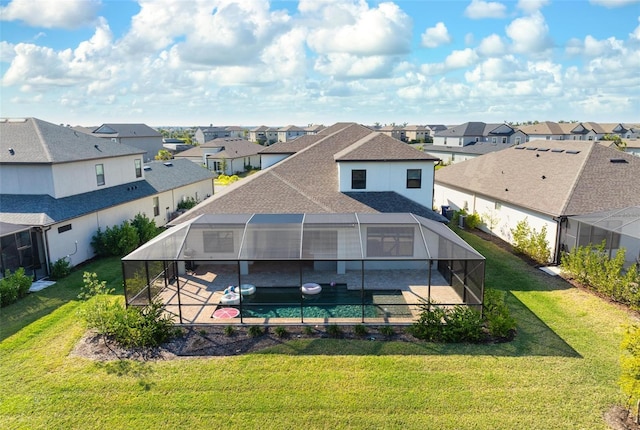 back of house with a patio, a yard, glass enclosure, and a residential view