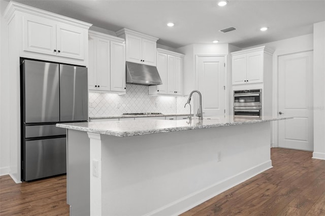 kitchen featuring visible vents, appliances with stainless steel finishes, white cabinets, a sink, and under cabinet range hood