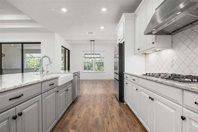 kitchen featuring visible vents, white cabinets, wall chimney exhaust hood, appliances with stainless steel finishes, and dark wood-style flooring