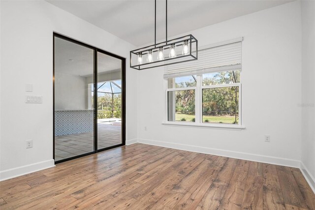 unfurnished dining area with baseboards and hardwood / wood-style floors