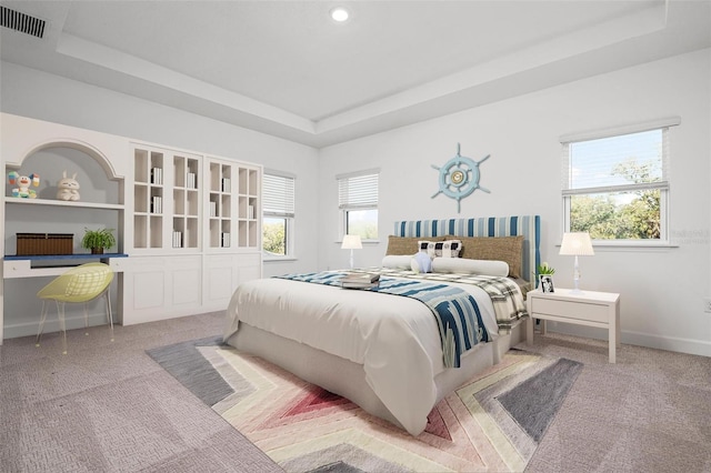 bedroom with multiple windows, a raised ceiling, visible vents, and baseboards