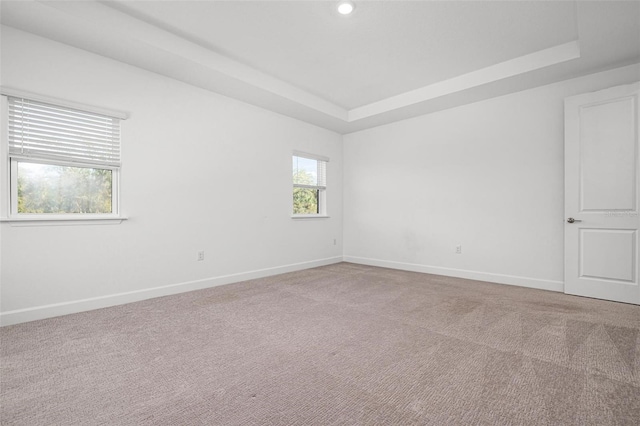 carpeted empty room with a tray ceiling, baseboards, and recessed lighting