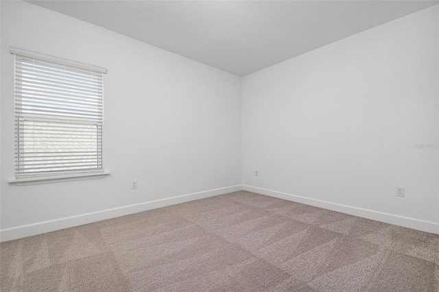 unfurnished room featuring carpet flooring and baseboards