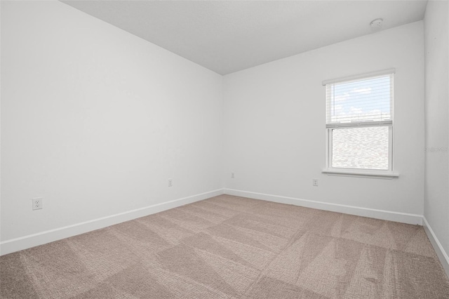 carpeted spare room with baseboards