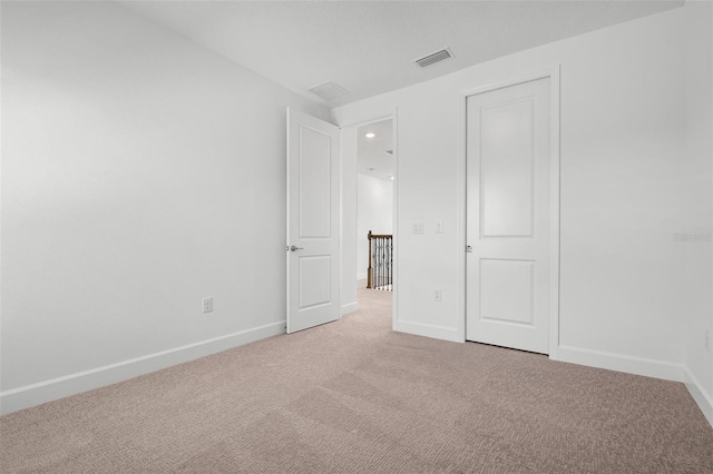 unfurnished bedroom with light colored carpet, visible vents, and baseboards