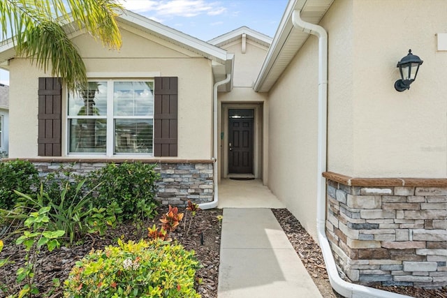 entrance to property with stone siding and stucco siding