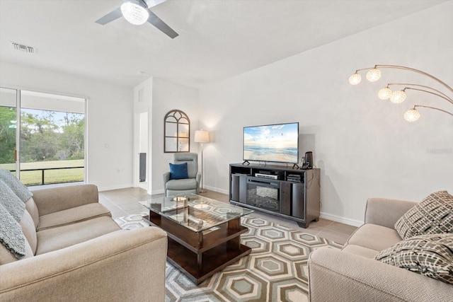 living area with a ceiling fan, light tile patterned flooring, visible vents, and baseboards