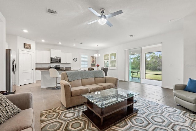 living area with light tile patterned floors, baseboards, visible vents, and recessed lighting