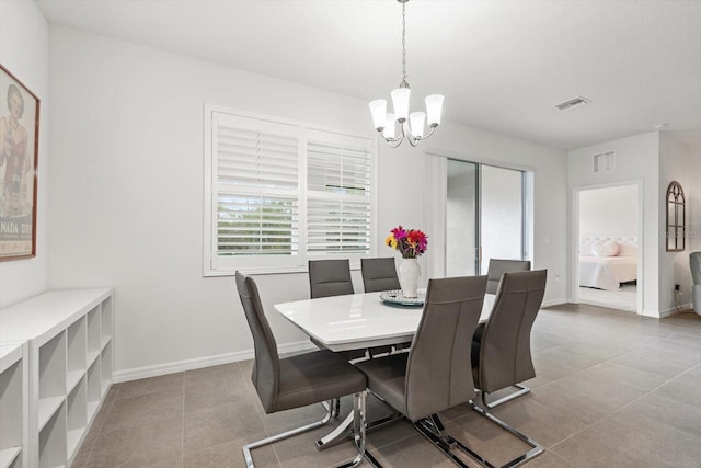 tiled dining space with a chandelier, visible vents, and baseboards