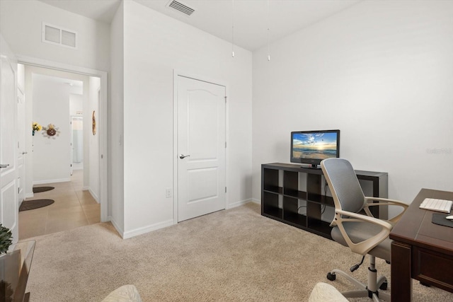 carpeted home office featuring attic access, a high ceiling, visible vents, and baseboards