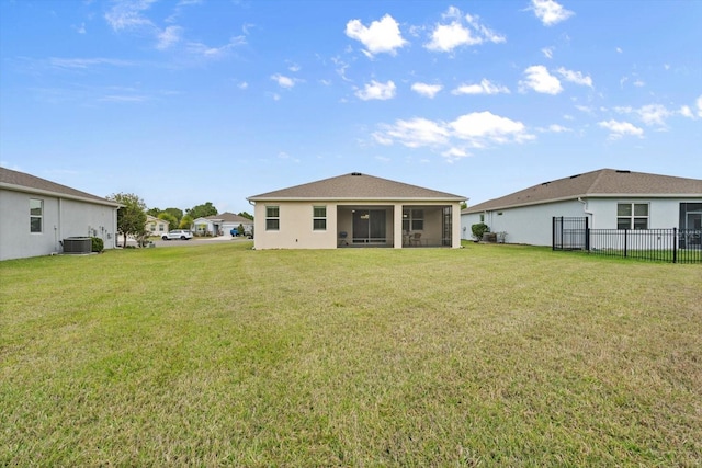 back of property featuring a sunroom, fence, cooling unit, and a lawn