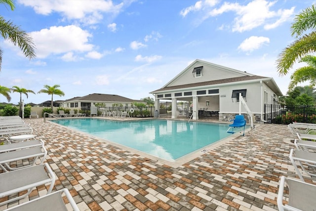 pool with a patio area and fence