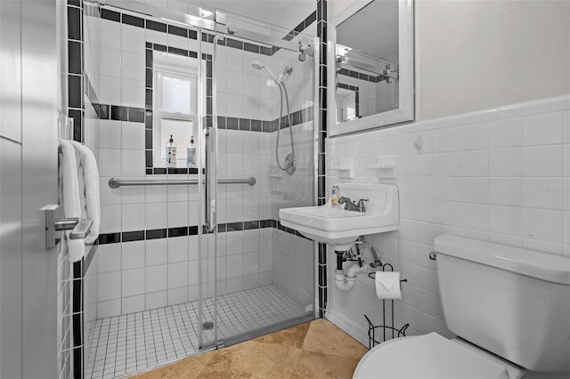 full bath with toilet, a shower stall, tile walls, and tile patterned floors