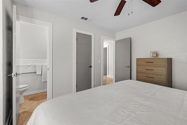 bedroom with ceiling fan, ensuite bath, and visible vents