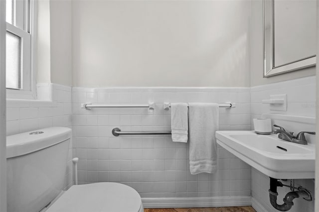 bathroom featuring a wainscoted wall and toilet