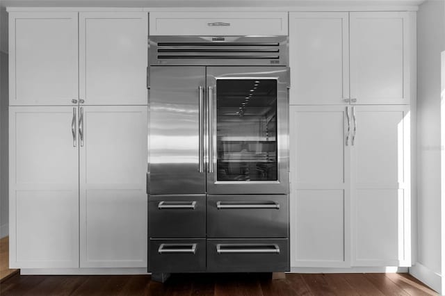 kitchen featuring white cabinetry, stainless steel built in refrigerator, and dark wood-style flooring