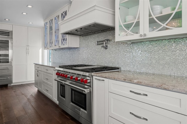 kitchen with double oven range, custom range hood, glass insert cabinets, and white cabinets