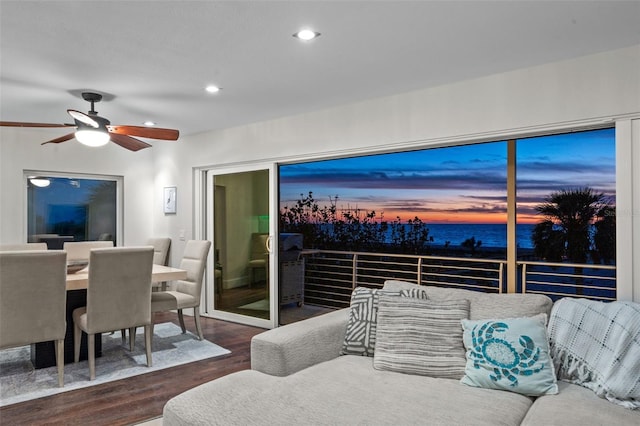 living area featuring a ceiling fan, recessed lighting, a water view, and wood finished floors