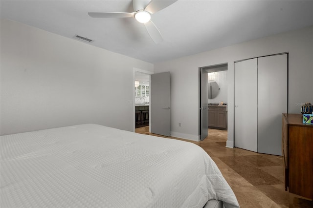 bedroom featuring a closet, visible vents, ceiling fan, a sink, and ensuite bath