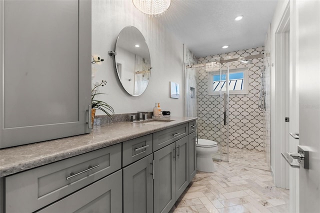 full bathroom featuring a textured ceiling, toilet, recessed lighting, vanity, and a shower stall