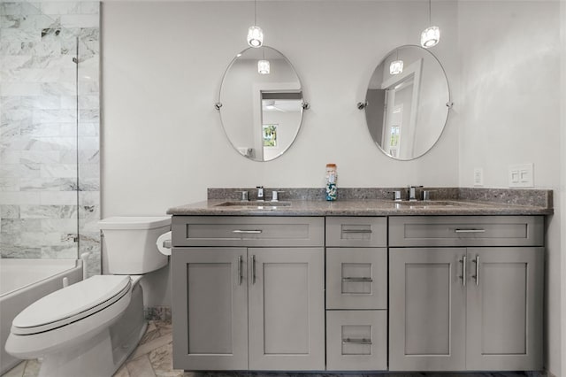 bathroom featuring marble finish floor, double vanity, a sink, and toilet