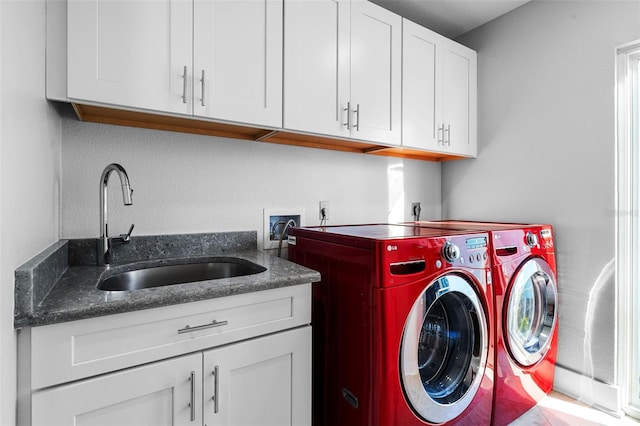 clothes washing area with cabinet space, washer and clothes dryer, and a sink