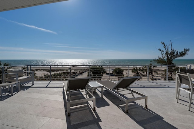 view of patio / terrace featuring a water view and a view of the beach