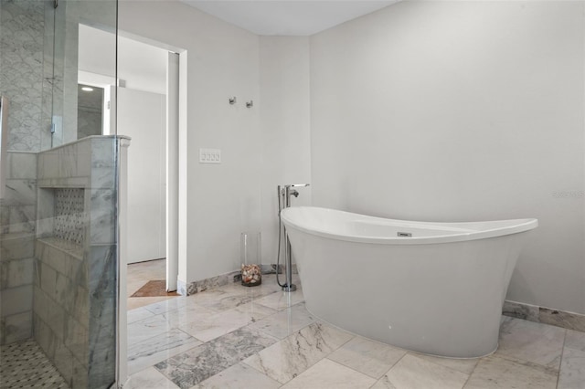 full bathroom with marble finish floor, a soaking tub, walk in shower, and baseboards