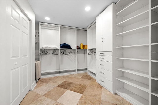 walk in closet with stone finish floor