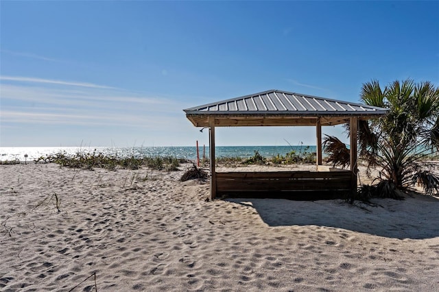 view of property's community with a water view and a beach view