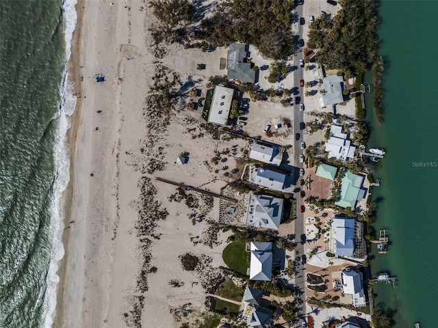 birds eye view of property featuring a water view and a beach view