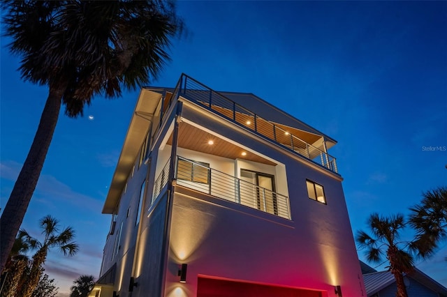 view of side of property with a balcony and stucco siding