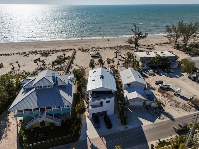 birds eye view of property featuring a water view and a beach view