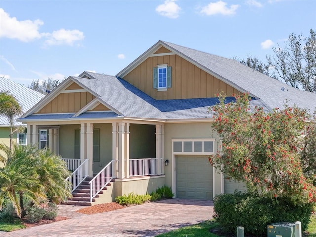 view of front of property with a porch, decorative driveway, board and batten siding, and a shingled roof