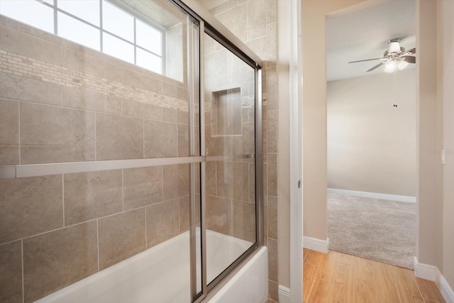 full bath with combined bath / shower with glass door, ceiling fan, baseboards, and wood finished floors