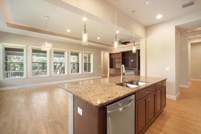 kitchen with visible vents, a center island with sink, a sink, open floor plan, and dishwasher