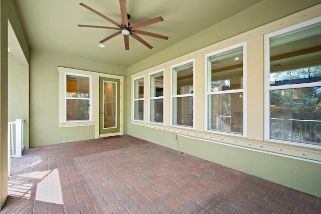 unfurnished sunroom featuring a ceiling fan