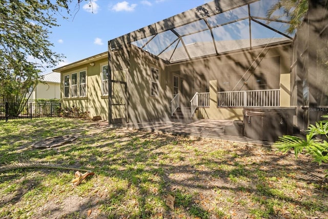 rear view of property with a patio area, a lanai, and fence