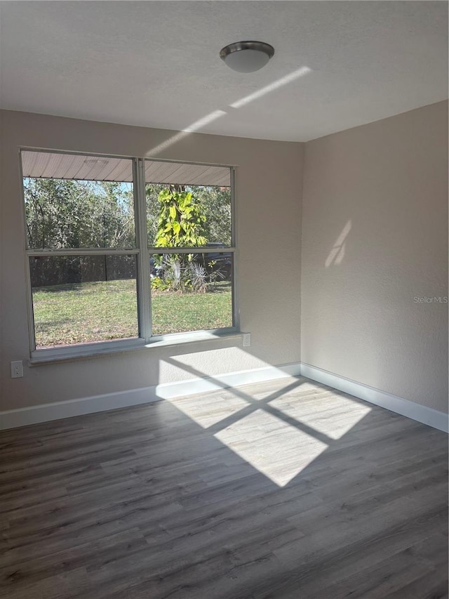 unfurnished room featuring wood finished floors and baseboards