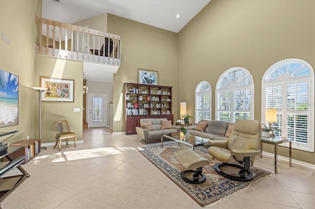 living area featuring high vaulted ceiling, tile patterned flooring, visible vents, and baseboards