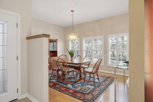 dining space featuring baseboards and a chandelier