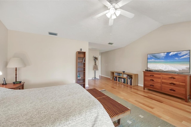 bedroom featuring visible vents, a ceiling fan, vaulted ceiling, wood finished floors, and baseboards