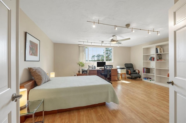 bedroom with a textured ceiling, a ceiling fan, and wood finished floors