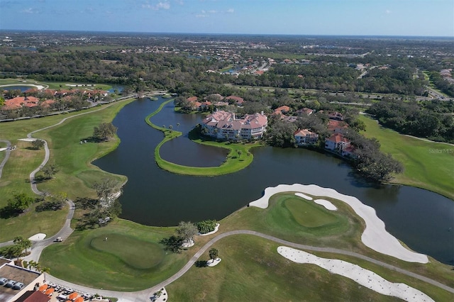 drone / aerial view with view of golf course and a water view