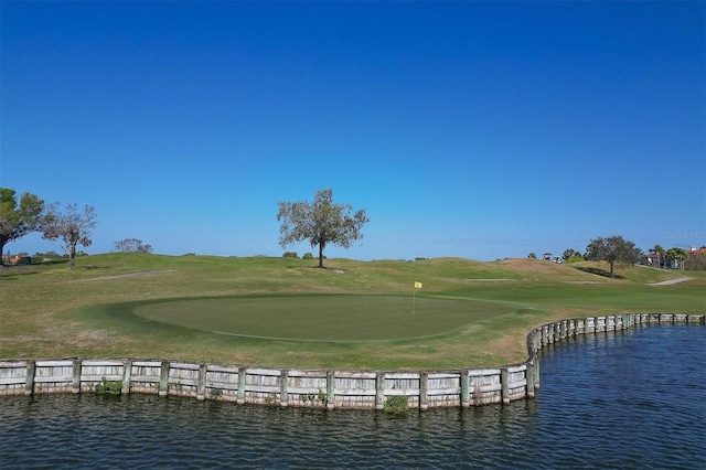 surrounding community featuring a water view, a lawn, and golf course view