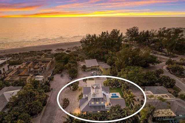 aerial view at dusk featuring a water view