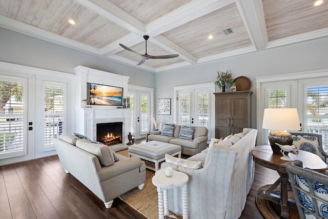 living area with french doors, visible vents, dark wood-type flooring, a warm lit fireplace, and beamed ceiling