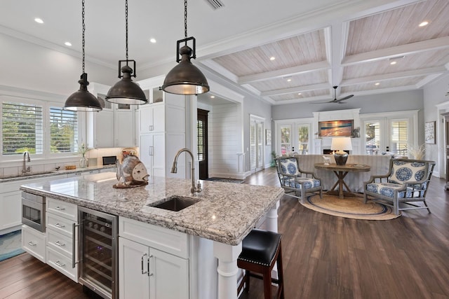 kitchen featuring a kitchen island with sink, wine cooler, a sink, and french doors